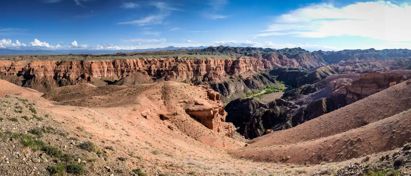 Wide panorama of Charyn Canyon showing the full extent of the eroded red rock gorge